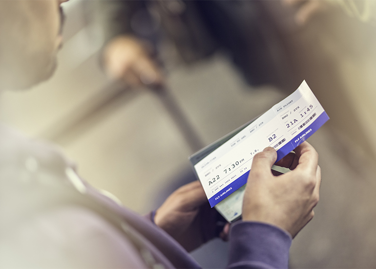 Close up of a man holding airplane ticket